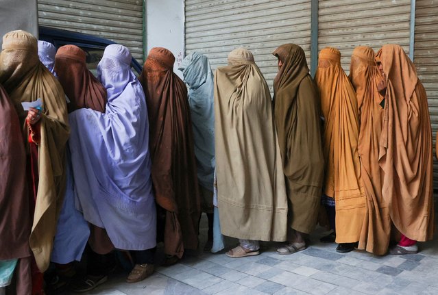 Veiled women wait in a line to receive free food being distributed during the Muslim holy month of Ramadan in Peshawar, Pakistan on March 18, 2025. (Photo by Fayaz Aziz/Reuters)