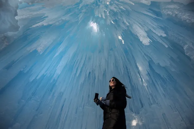 Deanne Ferguson looks around at icicles during a tour of the Ice Castles attraction in Edmonton, Alberta, Canada on Thursday, January 4, 2018. The ice castle is crafted by hand, using only icicles and water, and resembles organic formations found in nature. (Photo by Jason Franson/The Canadian Press via AP Photo)