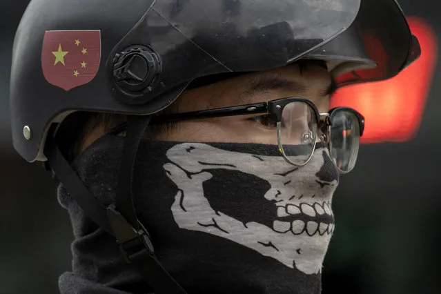 A delivery man wears a skull themed mask and a helmet with the Chinese flag colors on the streets of Beijing on Monday, August 31, 2020. Even as China has largely controlled the outbreak, the coronavirus is still surging across parts of the world. (Photo by Ng Han Guan/AP Photo)