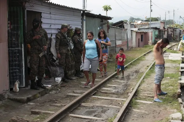 Army soldiers interrogates a suspected gang member during a patrol operation after residents flee the Amaya Community, due to threats from suspected gang members, in San Salvador, October 13, 2015. (Photo by Jose Cabezas/Reuters)