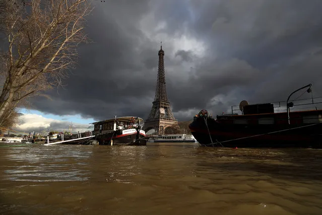 A view shows peniche houseboats moored and the Eiffel Tower along the flooded banks of the River Seine after days of almost non-stop rain caused flooding in the country in Paris, France on January 29, 2018. (Photo by Gonzalo Fuentes/Reuters)
