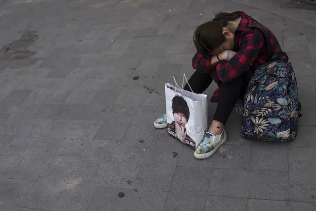 A woman takes a rest in a square near Beijing's famous Drum Tower on May 19, 2016. The sheer scale of the city and population can be exhausting. (Photo by Michael Robinson Chavez/The Washington Post)