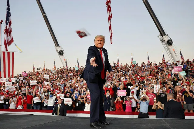 U.S. President Donald Trump tosses face masks to the crowd as he takes the stage for a campaign rally, his first since being treated for the coronavirus disease (COVID-19), at Orlando Sanford International Airport in Sanford, Florida, U.S., October 12, 2020. (Photo by Jonathan Ernst/Reuters)