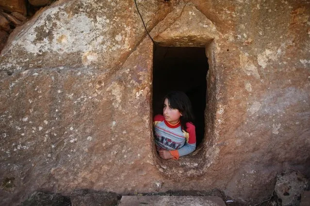 Nihal, 9, in the entrance of an underground Roman tomb used as shelter from Syrian government forces shelling and airstrikes, at Jabal al-Zaweya, in Idlib province,on February 28, 2013. Across northern Syria, rebels, soldiers, and civilians are making use of the country's wealth of ancient and medieval antiquities to protect themselves from Syria's two-year-old war. (Photo by Hussein Malla/AP Photo /The Atlantic)