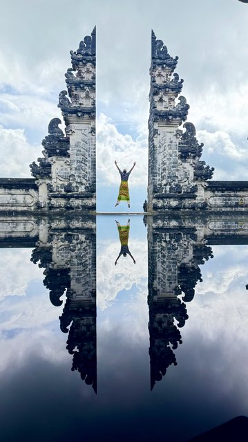 A tourist poses with a mirror-effect shot in front of Lempuyang Temple, one of Bali's most sacred sites, in Bali, Indonesia on June 14, 2025. Once known as the “Island of the Gods” for its serene and spiritual atmosphere, Bali is undergoing a transformation due to social media-driven tourism, with sacred places and natural sites turning into popular selfie spots. (Photo by Muhammet Tarhan/Anadolu via Getty Images)