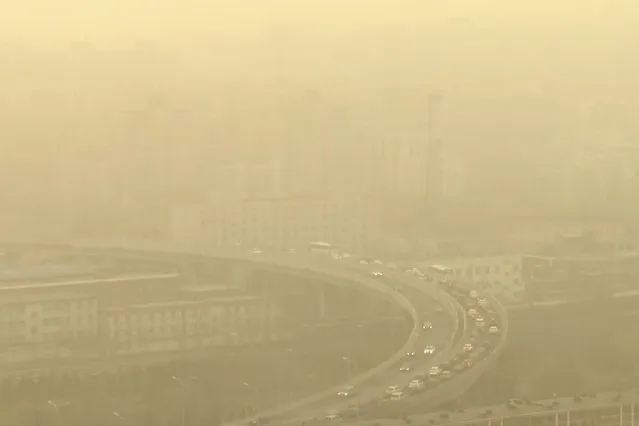 A view of a highway shot through a glass window during a dust storm in Beijing, Friday, March 10, 2023. Skyscrapers disappeared into the haze and air quality plummeted as China's capital was enveloped in a dust storm and heavy pollution on Friday. (Photo by Borg Wong/AP Photo)