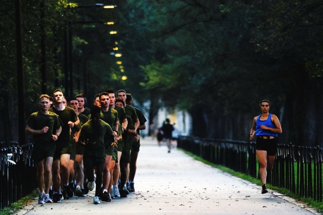 U.S. Marines run alongside a jogger during a morning training session in Washington on September 23, 2025. (Photo by Daniel Becerril/Reuters)