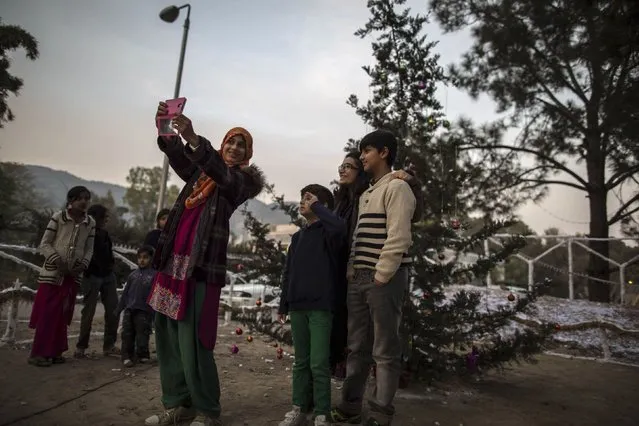 Muslims take a selfie near a Christmas tree ahead of Christmas in a Christian slum in Islamabad December 24, 2014. (Photo by Zohra Bensemra/Reuters)