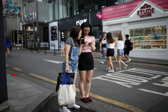 Women look at their moblie phones in the Hongdae area of Seoul, South Korea, June 29, 2016. Picture taken June 29, 2016. (Photo by Kim Hong-Ji/Reuters)