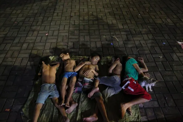 Children sleep on a square near a church in Manila, Philippines early October 18, 2016. People who have been spending their nights outside the church for a long time, say there are more people joining them since the beginning of the country's war on drugs. (Photo by Damir Sagolj/Reuters)