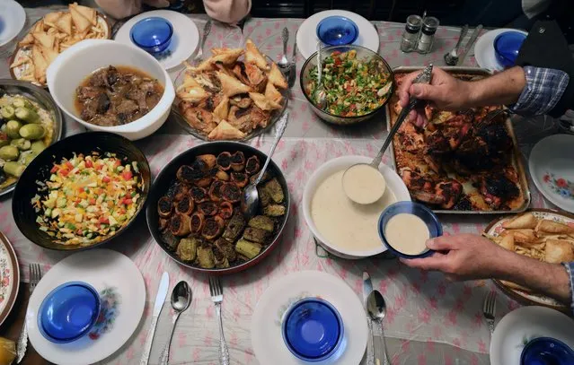 An Egyptian family prepares food for the Iftar meal on the first day of Ramadan in Cairo, Egypt, 23 March 2023. Iftar is the fast-breaking meal eaten by Muslims during the fasting month of Ramadan immediately after sunset. Muslims around the world celebrate Ramadan by praying during the night time and abstaining from eating, drinking, and sexual acts during the period between sunrise and sunset. Ramadan is the ninth month in the Islamic calendar and it is believed that the revelation of the first verse in the Koran was during its last 10 nights. (Photo by Khaled Elfiqi/EPA/EFE)