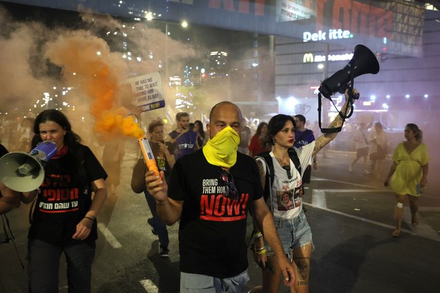 People light flares calling on the Israeli war cabinet to sign a hostage deal during a protest rally outside the Kirya military headquarters in Tel Aviv, Israel, 15 June 2024. According to the Israeli defense forces, around 120 Israelis hostages are still held by Hamas in Gaza. More than 36,000 Palestinians and over 1,400 Israelis have been killed, according to the Palestinian Health Ministry and the Israel Defense Forces (IDF), since Hamas militants launched an attack against Israel from the Gaza Strip on 07 October 2023, and the Israeli operations in Gaza and the West Bank which followed it. (Photo by Abir Sultan/EPA)