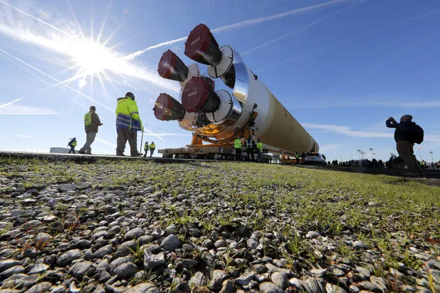 Security and safety personnel walk with the core stage of NASA's Space Launch System rocket, that will be used for the Artemis 1 Mission, as it is moved to the Pegasus barge, at the NASA Michoud Assembly Facility where it was built, in New Orleans, Wednesday, January 8, 2020. It will be transported to NASA's Stennis Space Center in Mississippi for its green run test. (Photo by Gerald Herbert/AP Photo)
