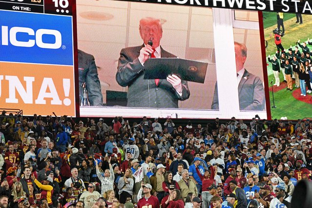 US President Donald Trump (C) reads the oath for people re-enlisting to the US army as he attends the NFL game between the Washington Commanders and the Detroit Lions at Northwest Stadium in Landover, Maryland, on November 9, 2025. (Photo by Mandel Ngan/AFP Photo)