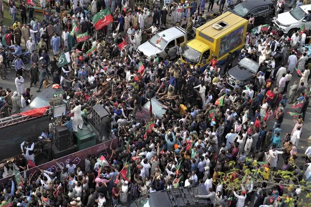 A vehicle, center, carrying former premier Imran Khan is surrounded by his supporters as he leads a rally to mark International Labor Day, in Lahore, Pakistan, Monday, May 1, 2023. (Photo by K.M. Chaudary/AP Photo)