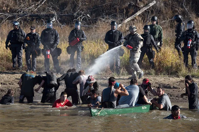 Police use pepper spray against protesters trying to cross a stream near an oil pipeline construction site near Standing Rock Indian Reservation, north of Cannon Ball, North Dakota, U.S. November 2, 2016. (Photo by Jason Patinkin/Reuters)