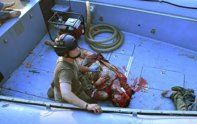 A Lebanese soldier tends to a wounded man, Amin al-Zahed, on a boat following of an explosion at the port of the capital Beirut, on August 4, 2020. Rescuers searched for survivors in Beirut after a cataclysmic explosion at the port sowed devastation across entire neighbourhoods, killing more than 100 people, wounding thousands and plunging Lebanon deeper into crisis. (Photo by AFP Photo/Stringer)