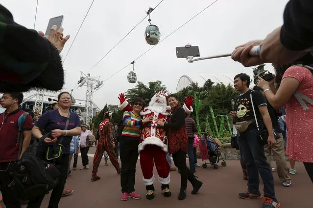 Visitors pose with a Santa Claus ahead of Christmas celebrations at Ocean Park in Hong Kong, China December 10, 2015. (Photo by Bobby Yip/Reuters)
