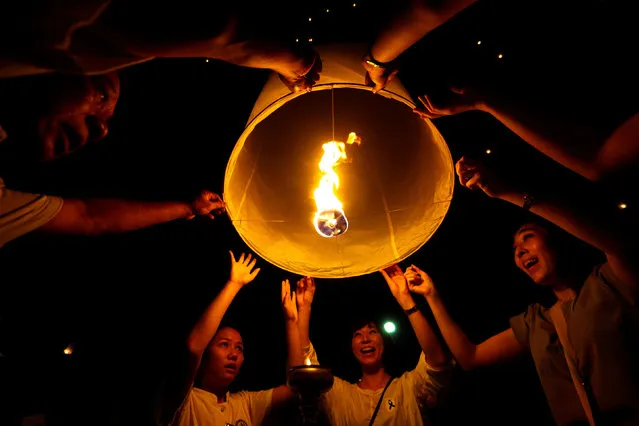People hold up floating lanterns before they release during the festival of Yee Peng in the northern capital of Chiang Mai, Thailand November 14, 2016. (Photo by Athit Perawongmetha/Reuters)
