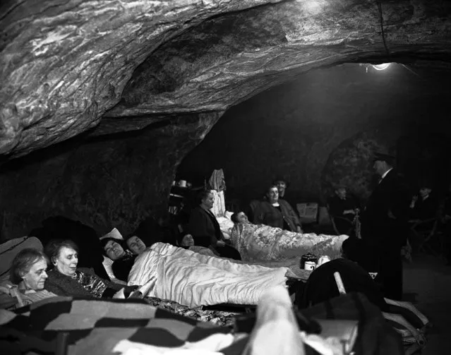 Hundreds of people, many of whom have lost their homes through bombing, now use the caves in Hastings, a south-east English town, on December 12, 1940, as their nightly refuge. Thousands of holidaymakers have toured these caves in peace time and legend links them with smugglers, but now they are serving a much more useful purpose. Special sections are reserved for games and recreation, and several people have 'set up house', bringing their own furniture and sleeping on their own beds. The local council are shortly going to install bunks and concrete the floors of the caves. (Photo by AP Photo)