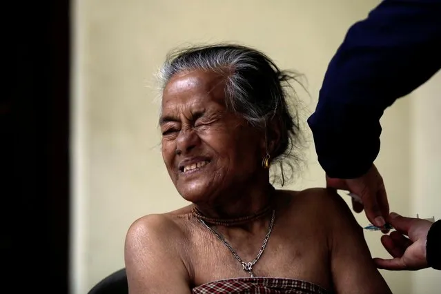 A woman reacts as she gets vaccinated against the coronavirus disease (COVID-19) as the government started a campaign to vaccinate elderly people above 65 years old, in Lalitpur, Nepal on March 7, 2021. (Photo by Navesh Chitrakar/Reuters)