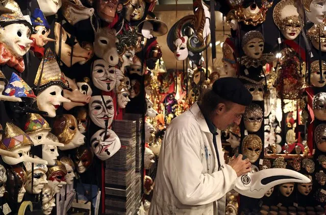 Iranian mask artisan Hamid works on a carnival mask in his shop “Ca' del Sol” near St. Mark's square during the first day of carnival in Venice February 1, 2015. (Photo by Stefano Rellandini/Reuters)