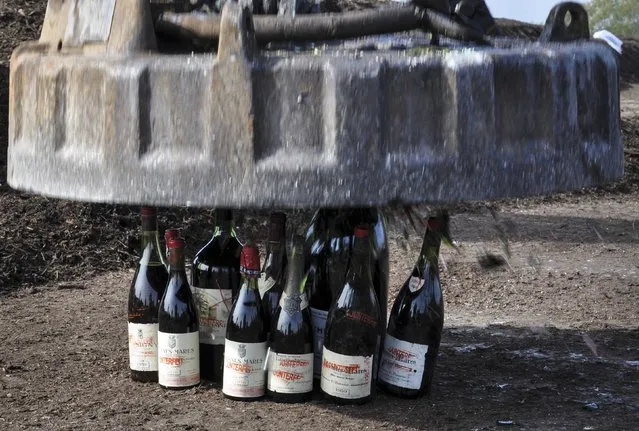 More than 500 bottles of wine found to be counterfeit or unsellable are destroyed at a landfill in Creedmoor, Texas in this December 10, 2015 US Marshals photo. The wine was from the private collection of Rudy Kurniawan, the man convicted of fraud in federal court in 2013 for producing and selling millions of dollars of counterfeit wine. (Photo by Lynzey Donahue/Reuters/US Marshals)