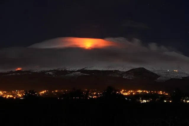 A volcanic eruption illuminates the clouds around the Etna volcano, near Catania, Sicily island, southern Italy, early February 2, 2015. The eruptions are reported to have begun on 31 January 2015 at Mount Etna's new south east crater. (Photo by Davide Cautullo/EPA)