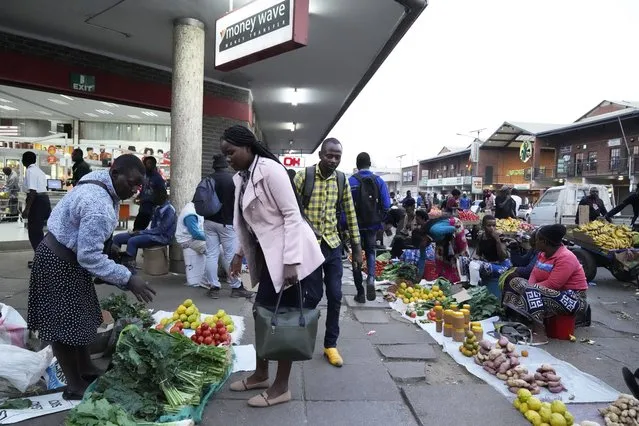 Street traders sell various goods outside a supermarket on the streets of Harare, in this Monday, May, 22, 2023 photo. Shoppers in Zimbabwe are increasingly turning to street traders to buy what they need as the local currency plunges in value against the U.S. dollar.Street traders in cars, on bicycles or on foot clog sidewalks, roads and parking spaces. They sell items ranging from groceries to cosmetics, brooms, dog chains, car parts and medicines.(Photo by Tsvangirayi Mukwazhi/AP Photo)