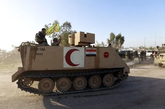 Iraqi security forces and Shi'ite Fighters sit on an armoured vehicle in Salahuddin province March 2, 2015. Iraq's armed forces, backed by Shi'ite militia, attacked Islamic State strongholds north of Baghdad on Monday as they launched an offensive to retake the city of Tikrit and the surrounding Sunni Muslim province of Salahuddin. REUTERS/Thaier Al-Sudani 