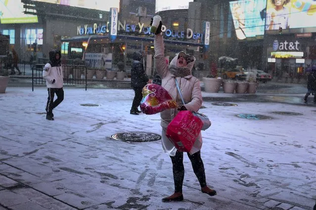 A woman twirls and dances in celebration as it begins to snow in Times Square in the Manhattan borough of New York, January 23, 2016. (Photo by Carlo Allegri/Reuters)