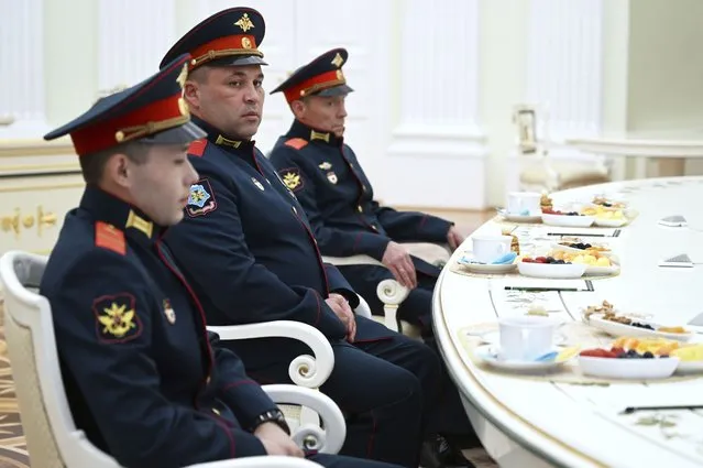 From left: Russian servicemen Cpl. Alexei Ivliev, awarded with the Order of Courage and Hero of the Russian Federation, Pvt. Ivan Kalashnikov and Pvt. Vyacheslav Tarasov, awarded with the Order of Courage, all of them participants of Russian special military operation, attend a meeting with Russian President Vladimir Putin at the Kremlin in Moscow, Russia, Friday, September 29, 2023. (Photo by Pavel Bednyakov, Sputnik, Kremlin Pool Photo via AP Photo)