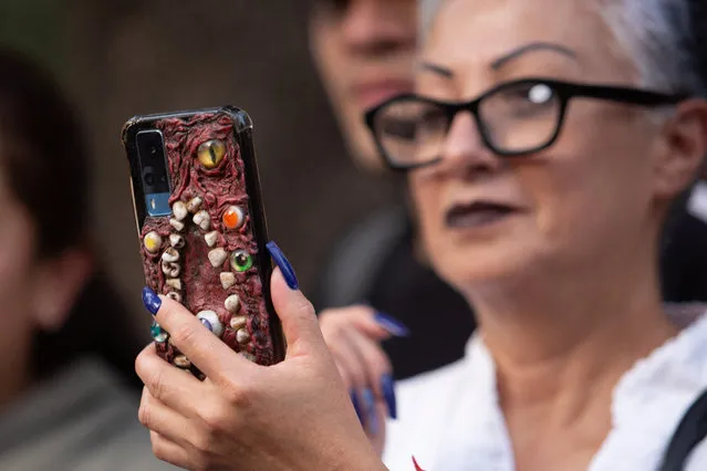 A woman uses a phone during the annual Zombie Walk in Mexico City, Mexico on October 21, 2023. (Photo by Quetzalli Nicte-Ha/Reuters)