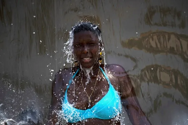 A woman cools off in a water fountain at Madureira Park amid a heat wave in Rio de Janeiro, Brazil, Wednesday, November 15, 2023. (Photo by Bruna Prado/AP Photo)