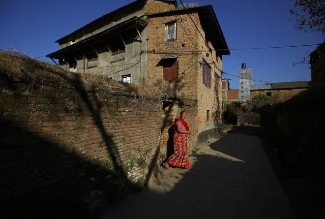 A woman walks out from a house at Sankhu in Kathmandu January 28, 2015. (Photo by Navesh Chitrakar/Reuters)