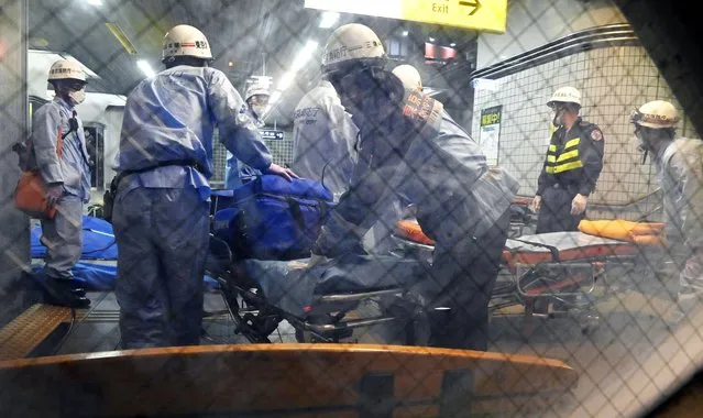 Rescuers papare stretchers at Soshigaya Okura Station after stabbing on a commuter train, in Tokyo Friday, August 6, 2021. A man with a knife stabbed passengers on a commuter train Friday and was arrested by police after fleeing, fire department officials and news reports said. (Photo by Kyodo News via AP Photo)