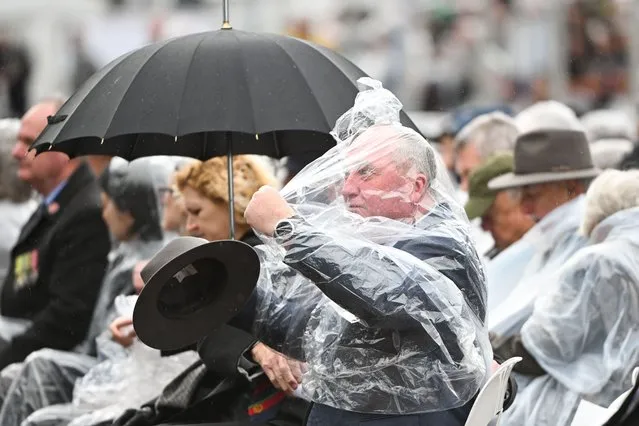 Shadow Veterans’ Affairs Minister Barnaby Joyce struggles to get into a rain poncho during the National Commemorative Service for the 50th anniversary of the end of Australia’s involvement in the Vietnam War at the Australian Forces National Memorial in Canberra, Friday, August 18, 2023. (Photo by Lukas Coch/AAP Image)