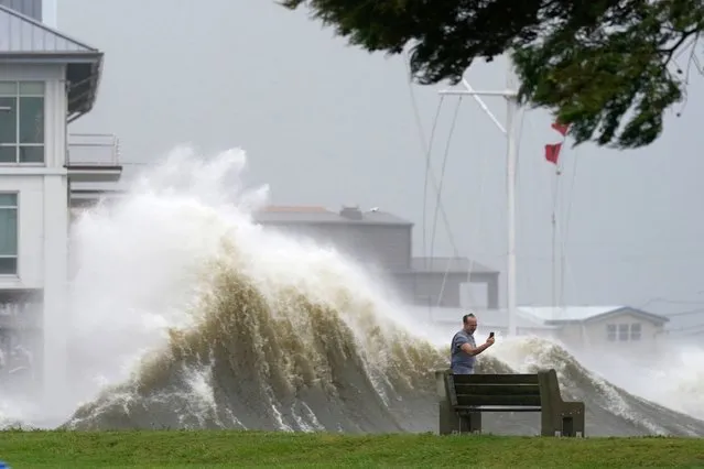 A man takes pictures of high waves along the shore of Lake Pontchartrain as Hurricane Ida nears, Sunday, August 29, 2021, in New Orleans. (Photo by Gerald Herbert/AP Photo)
