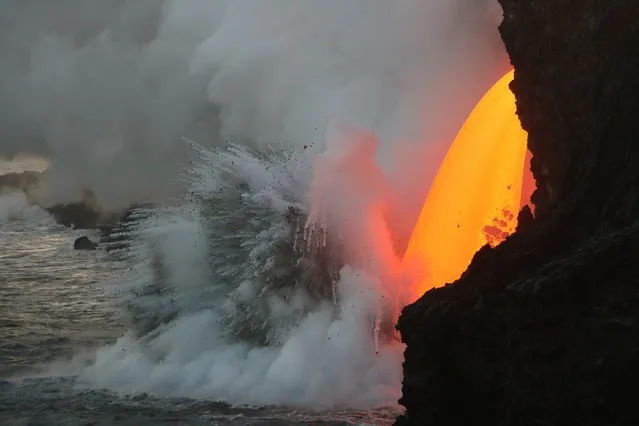 This image obtained January 31, 2017 from the US Geological Survey's Hawaiian Volcano Observatory showing a  lava stream, pouring out of the lava tube on the sea cliff at the Kamokuna ocean entry from the Kilauea Volcano on January 29. (Photo by AFP Photo/USGS)