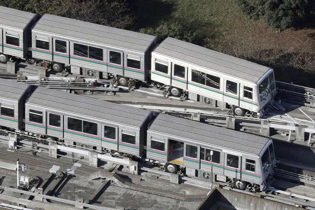 A train, above, of the Nippori-Toneri Liner, an automated guideway transit system, sits derailed in Tokyo Friday, October 8, 2021, following an earthquake on Thursday. The powerful earthquake shook the Tokyo area on Thursday night, damaging underground water pipes and halting trains and subways. (Photo by Kyodo News via AP Photo)