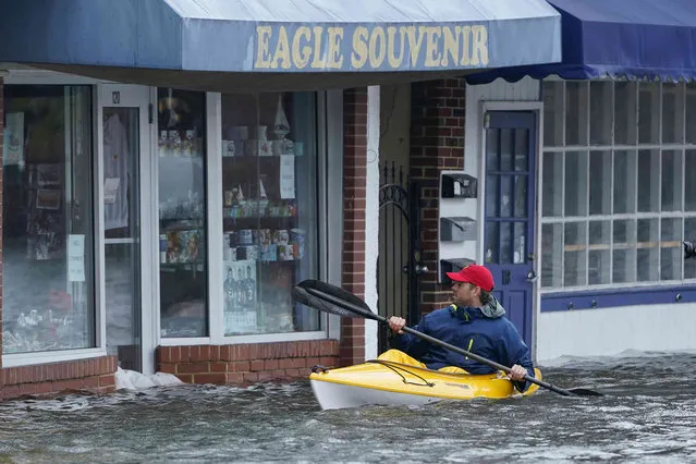 Chase Sutton, left, of Annapolis, Md., kayaks over a sidewalk in downtown Annapolis, Md., Friday, October 29, 2021, as he surveys the flooding. The city is anticipating potential historic tidal flooding conditions in low-lying areas Friday and Saturday. (Photo by Susan Walsh/AP Photo)