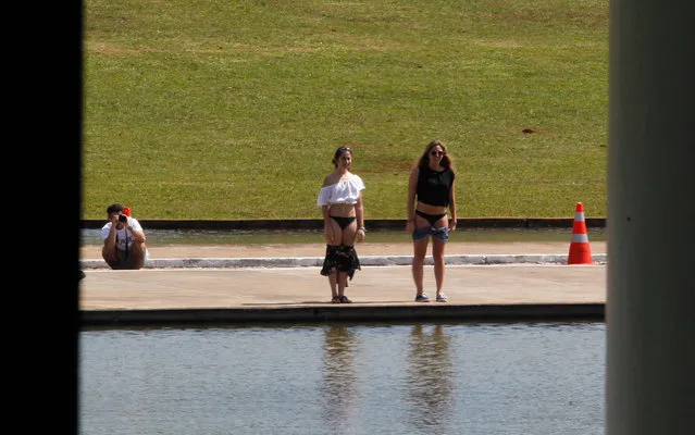 Tourists pose for underwear photo in front of the reflecting pool of the National Congress in Brasilia on May 8, 2015. The act happened quickly and was not reprimanded by security. (Photo by Givaldo Barbosa/Agência O Globo)