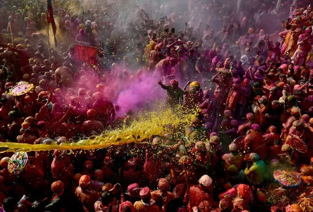 Men daubed in colours throw colours at each other during “Lathmar Holi” celebrations inside a temple premises in the town of Nandgaon, Uttar Pradesh, India on March 19, 2024. (Photo by Ritesh Shukla/Reuters)
