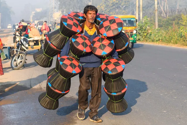 A vendor selling stools looks for customers along a street in Amritsar on December 10, 2021. (Photo by Narinder Nanu/AFP Photo)