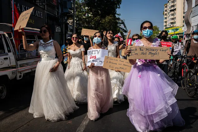 Protesters dressed in bridal costumes take part in a march against the military coup on February 10, 2021 in Yangon, Myanmar. Myanmar declared martial law in parts of the country, including its two largest cities, as massive protests continued to draw people to the streets a week after the country's military junta staged a coup against the elected National League For Democracy (NLD) government and detained de-facto leader Aung San Suu Kyi. Police fired rubber bullets, tear gas, and water cannon to disperse protesters at demonstrations across the country, and at least two people were in critical condition from the injuries sustained. (Photo by Hkun Lat/Getty Images)