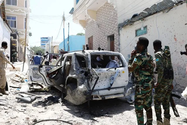 Somali security look at the wreckage of a vehicle at the scene of an explosion Mogadishu, Somalia January 16, 2022. (Photo by Feisal Omar/Reuters)