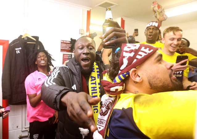 Stormzy, British Rap artist and co owner of AFC Croyden Athletic celebrates promotion with the AFC Croyden Athletic players in the changing room after the Combined Counties Premier League South Play Off Final between Knaphill FC v AFC Croydon Athletic at Redding Way on May 07, 2024 in Woking, England. (Photo by Warren Little/Getty Images)