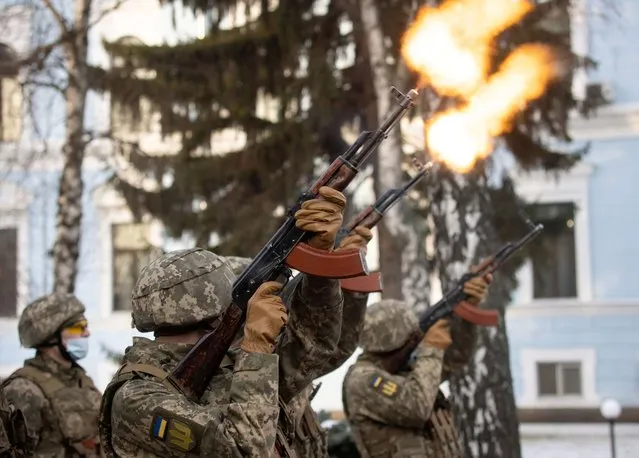 Service members fire a salute during a ceremony in tribute to fallen defenders of Ukraine, including the soldiers killed during a battle with pro-Russian rebels for the Donetsk airport this day in 2015, at a memorial near the headquarters of the Defence Ministry in Kyiv, Ukraine January 20, 2022. (Photo by Ukrainian Presidential Press Service/Handout via Reuters)