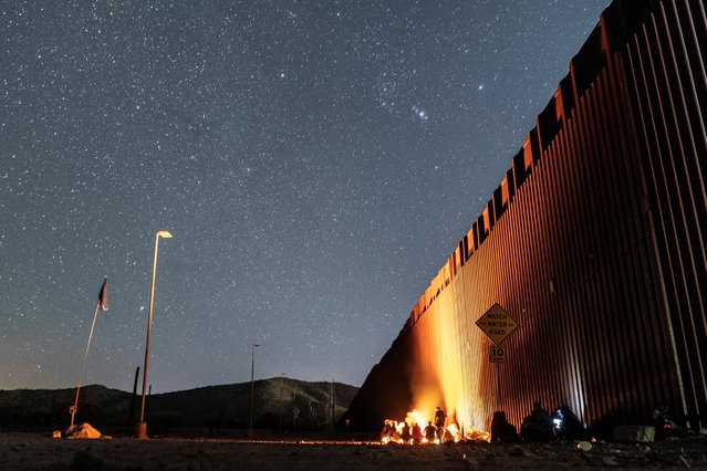 Migrants wait to be transported by the U.S. border patrol after crossing the border wall into the U.S. from Mexico, as the number of migrants surges in the border town of Lukeville, Arizona, U.S. December 13, 2023. (Photo by Go Nakamura/Reuters)