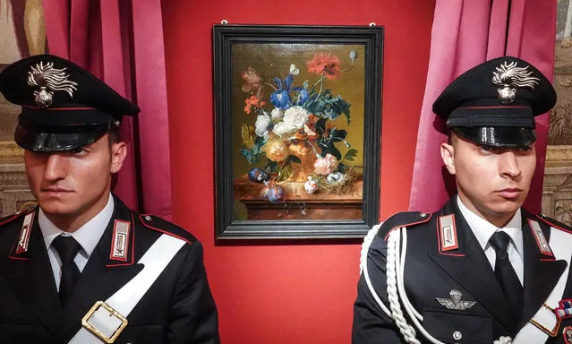 Policemen stand guard next to the veiled painting “Vase of Flowers” by Dutch artist Jan van Huysum during its return ceremony at the Pitti Palace, part of the Uffizi Gallery in Florence, Italy, 19 July 2019. The artwork was stolen by Nazi troops during World War II. (Photo by Claudio Fusi/Rex Features/Shutterstock)